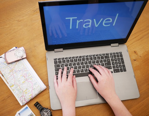 Laptop mit Userin bei der Reiseplanung